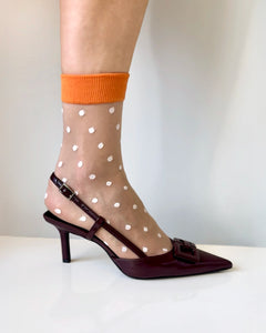 Women's sheer socks with white polka dots and orange rim. Trending polka dot socks. Chic fashion socks with high heel shoes. Most wanted fashion crew socks.